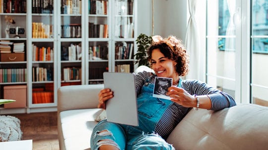 Woman sharing a sonogram on a video call